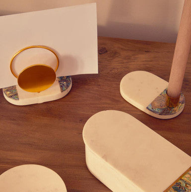 Decorative items including a cylindrical box, coasters, and a small cup on a wooden surface.