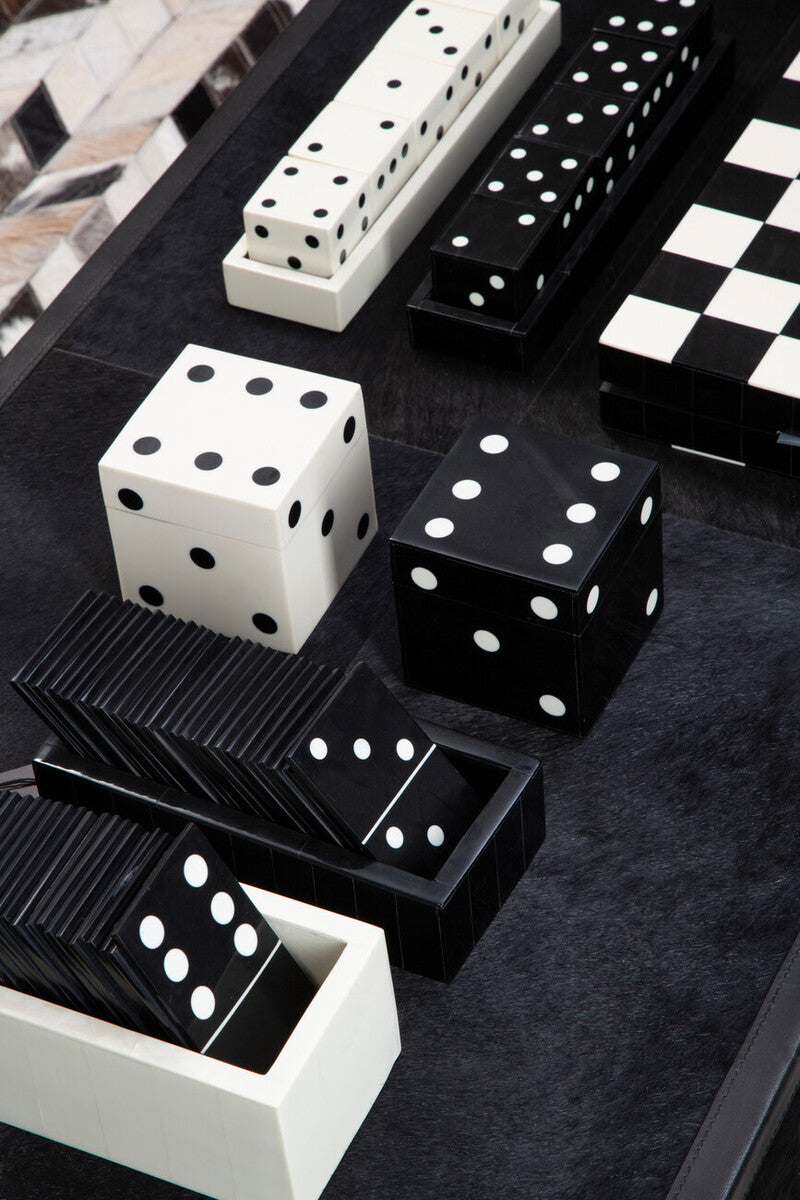 Black and white dice and dominoes on a dark surface