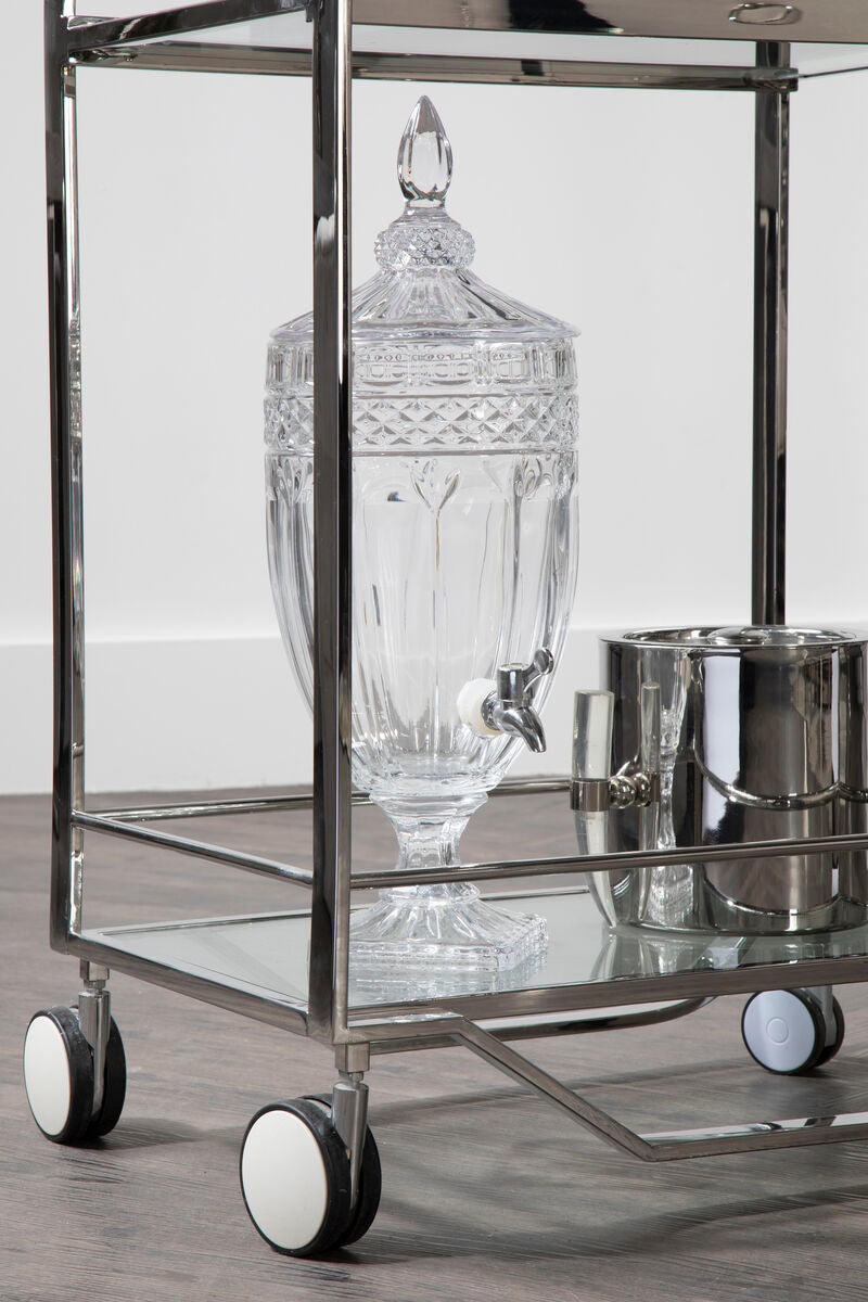 Decorative glass container on a metal bar cart with a white background