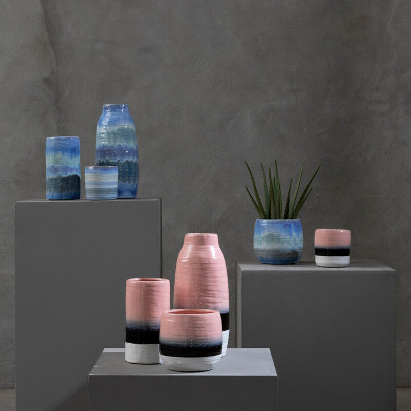 Collection of ceramic vases with blue and pink glaze on a gray background