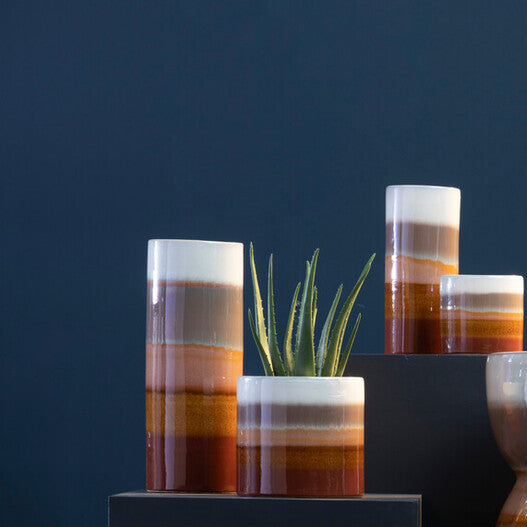 Collection of ceramic vases with striped patterns on a dark blue background