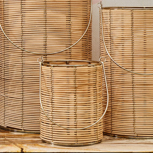 Three woven baskets of different sizes on a wooden surface with a abstract wall art in the background.