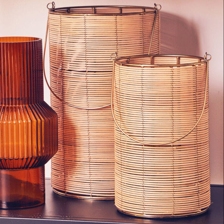 Three decorative lamps with ribbed textures on a shelf against a light pink wall.