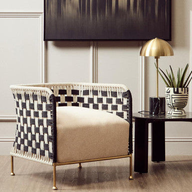 Decorative armchair with checkered backrest in a stylish room with a lamp and plant.