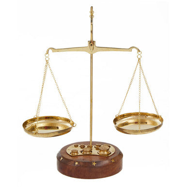Gold balance scale with wooden base on a white background