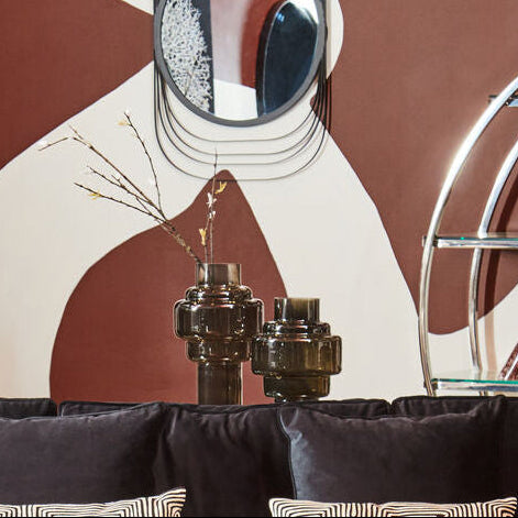 Modern living room with a black sofa, round coffee table, and decorative wall art.