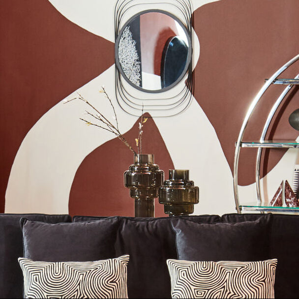 Modern living room with a black sofa, round coffee table, and decorative wall art.