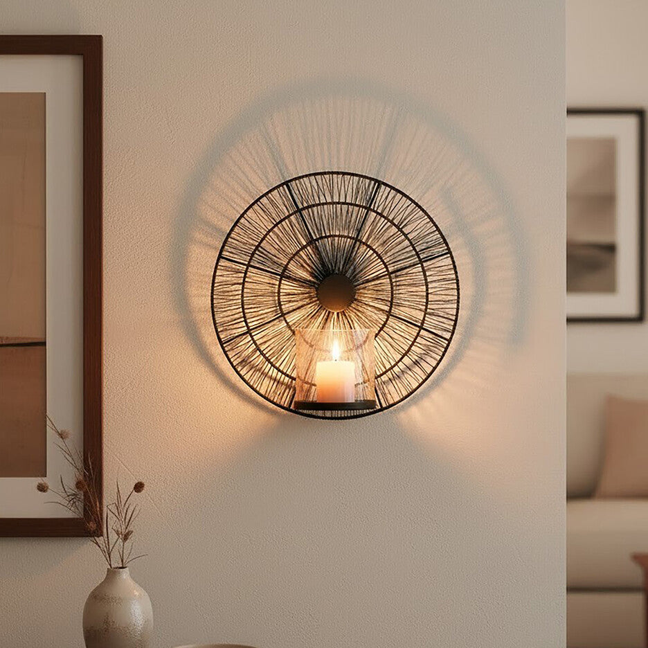 Decorative wall light fixture in a living room setting with a vase and bowl on a table.