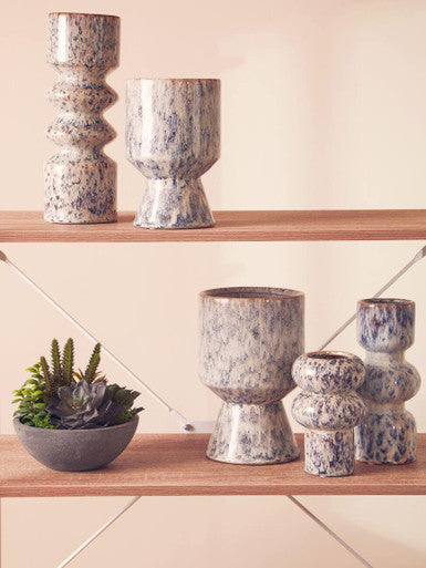 Set of ceramic pots and a bowl on wooden shelves against a light background