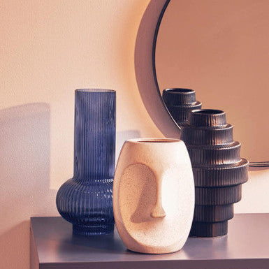 Decorative vases on a shelf with a mirror in the background