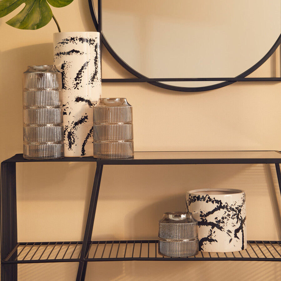 Decorative shelf with vases and a mirror on a beige wall