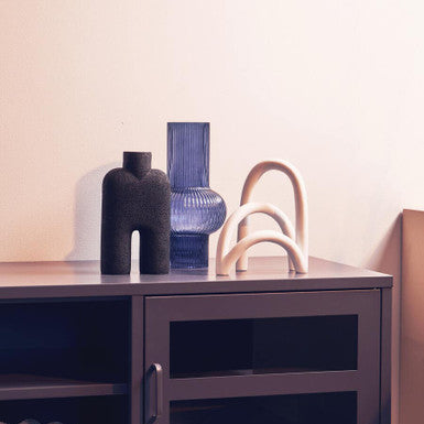 Modern interior with a dark wooden cabinet and decorative vases on a light background
