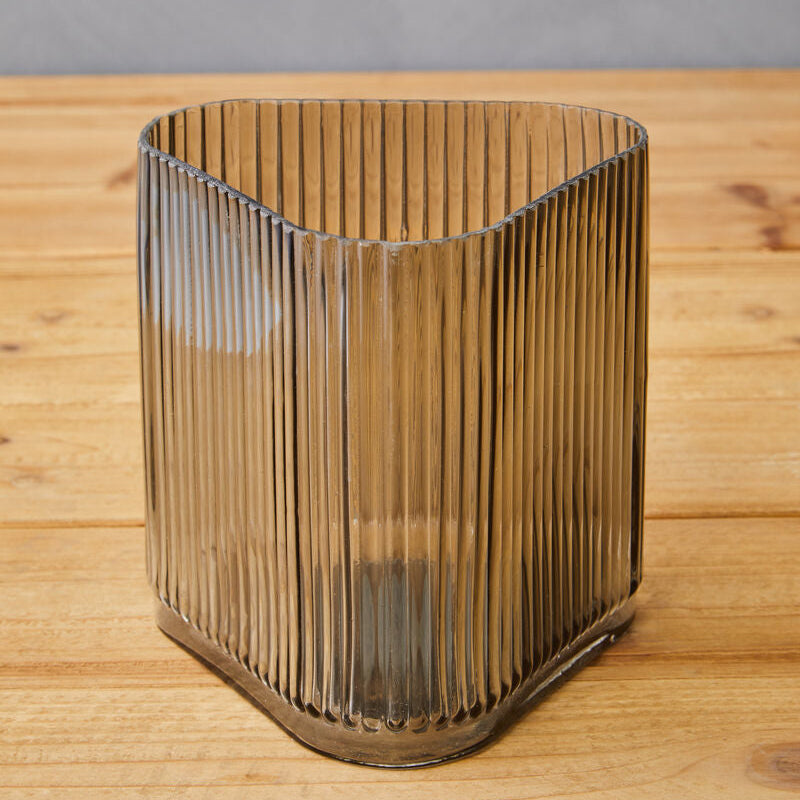 Glass vase with ribbed design on a wooden surface