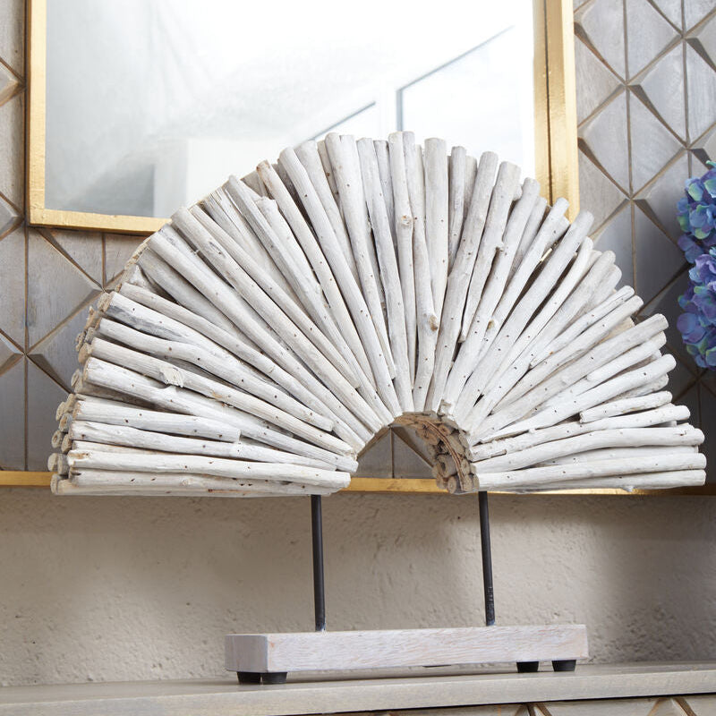 Decorative arch made of white sticks on a shelf with a geometric tile pattern in the background