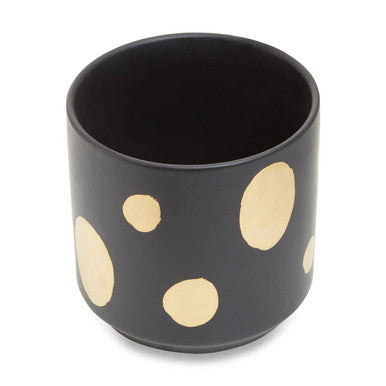 Black cup with gold polka dots on a white background