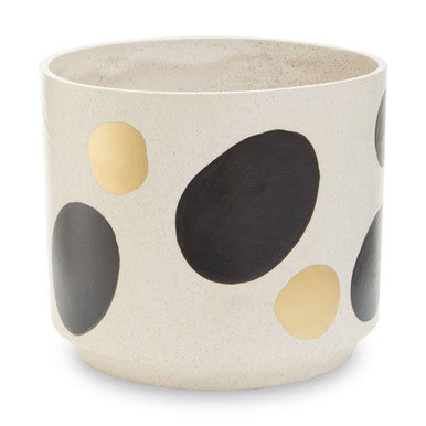 Decorative pot with black and gold polka dots on a beige background