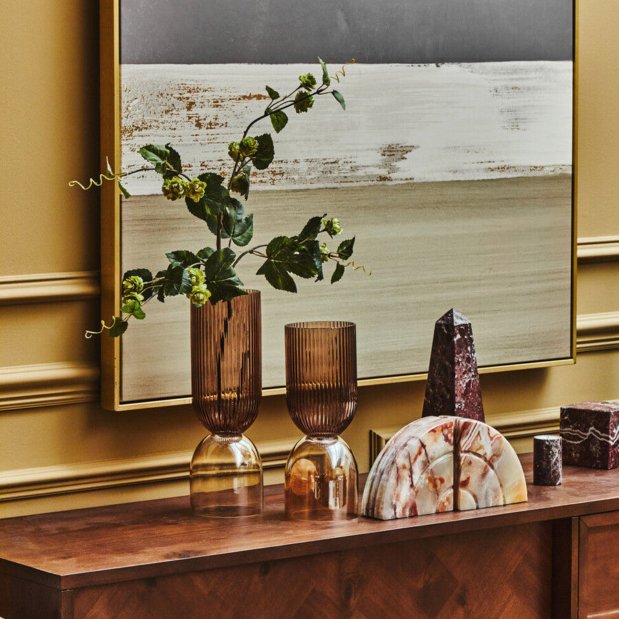 Decorative items on a wooden console table with a large mirror in the background.