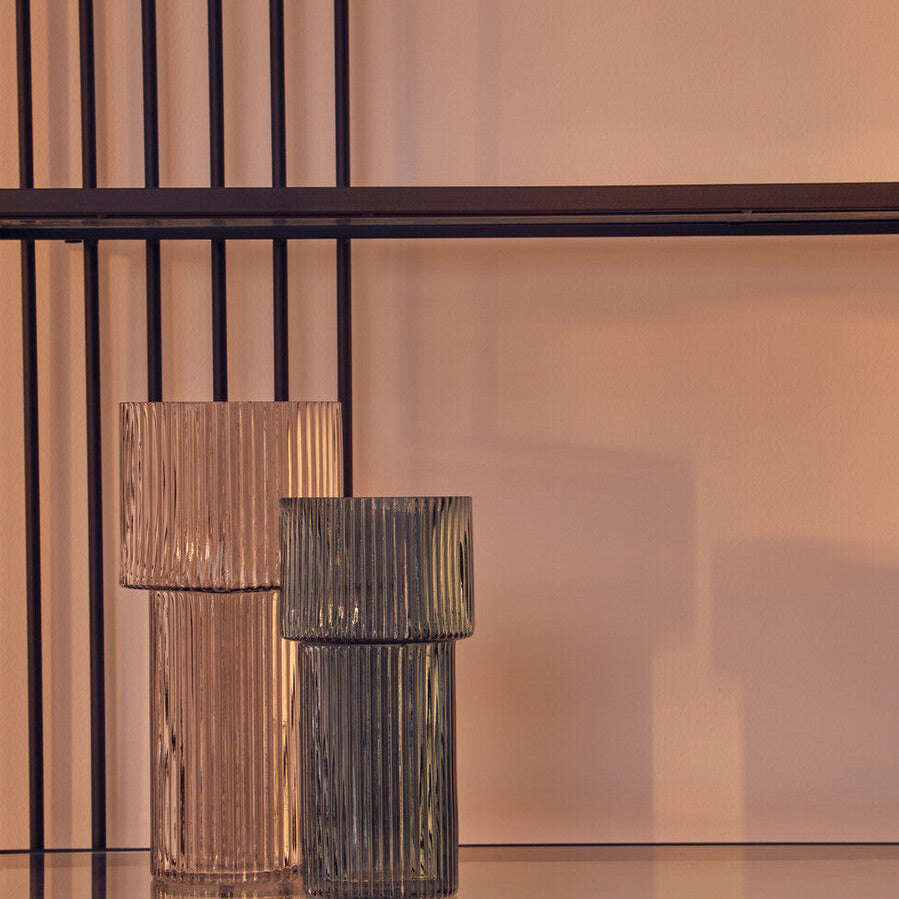 Two decorative vases on a reflective surface with a blurred background