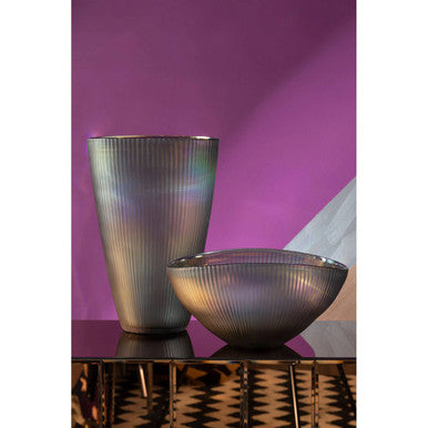 Decorative glass vase and bowl on a reflective surface with a purple background