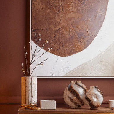 Decorative setup with vases, a vase, and a wall art piece in a room.