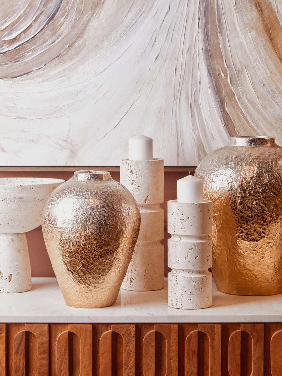 Decorative vases and candles on a marble surface with a marble wall background