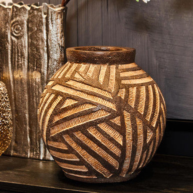 Decorative terracotta vase with geometric pattern on a wooden surface