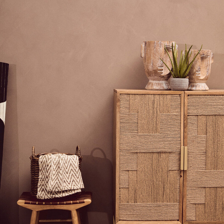 Wooden cabinet with decorative items against a brown wall