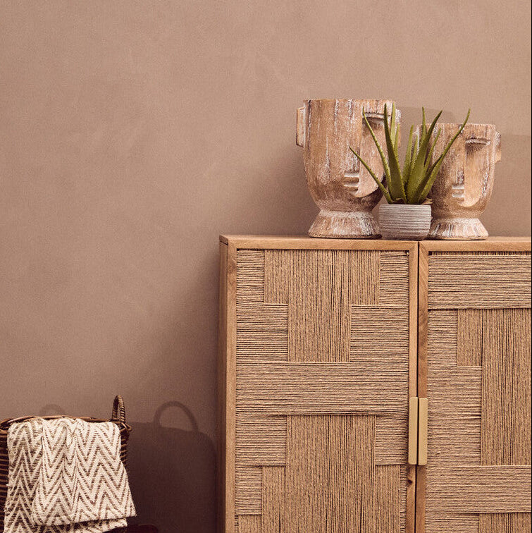 Wooden cabinet with decorative items against a brown wall