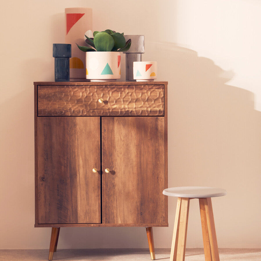 Wooden cabinet with decorative items and a stool in a room setting