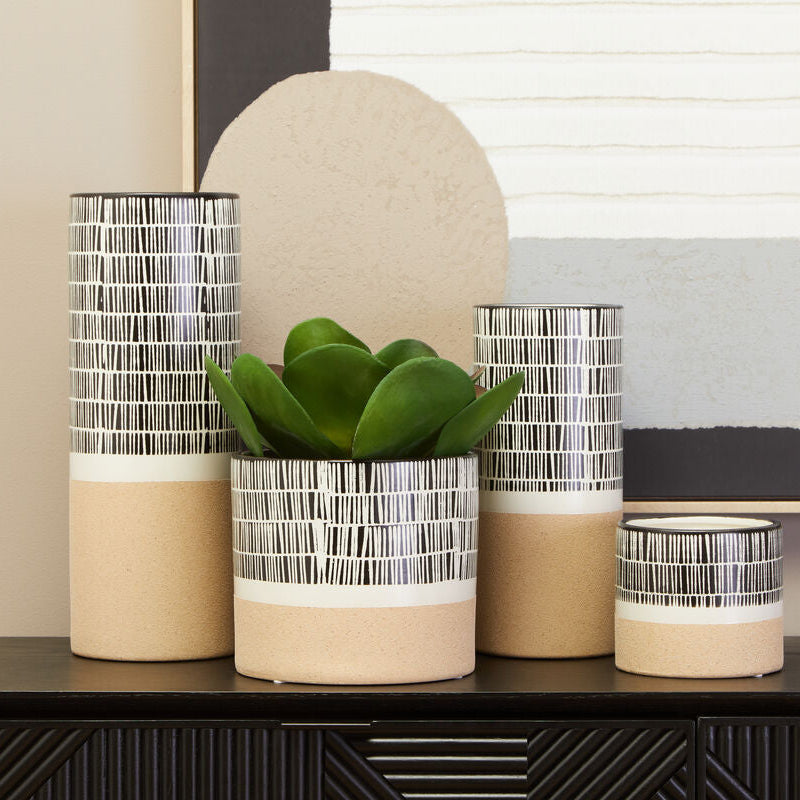 Set of decorative vases with striped patterns on a surface.