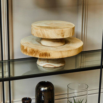 Decorative shelf with wooden cake stand, glass vase, and ceramic jars.