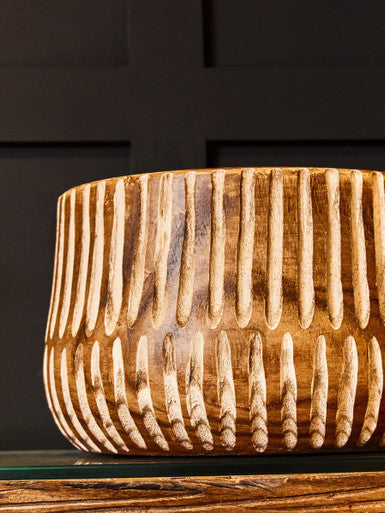 Wooden vase with textured design on a dark background