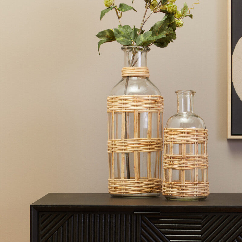 Black cabinet with two glass vases with wicker baskets on a beige wall background