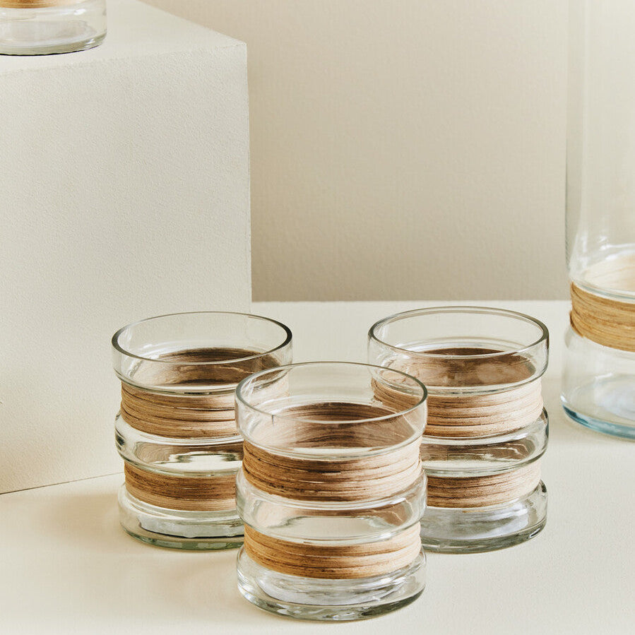 Set of glass containers with wooden bands on a neutral background