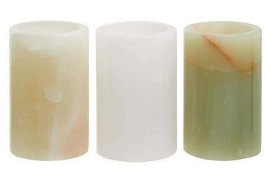 Three cylindrical candles with different color patterns on a white background