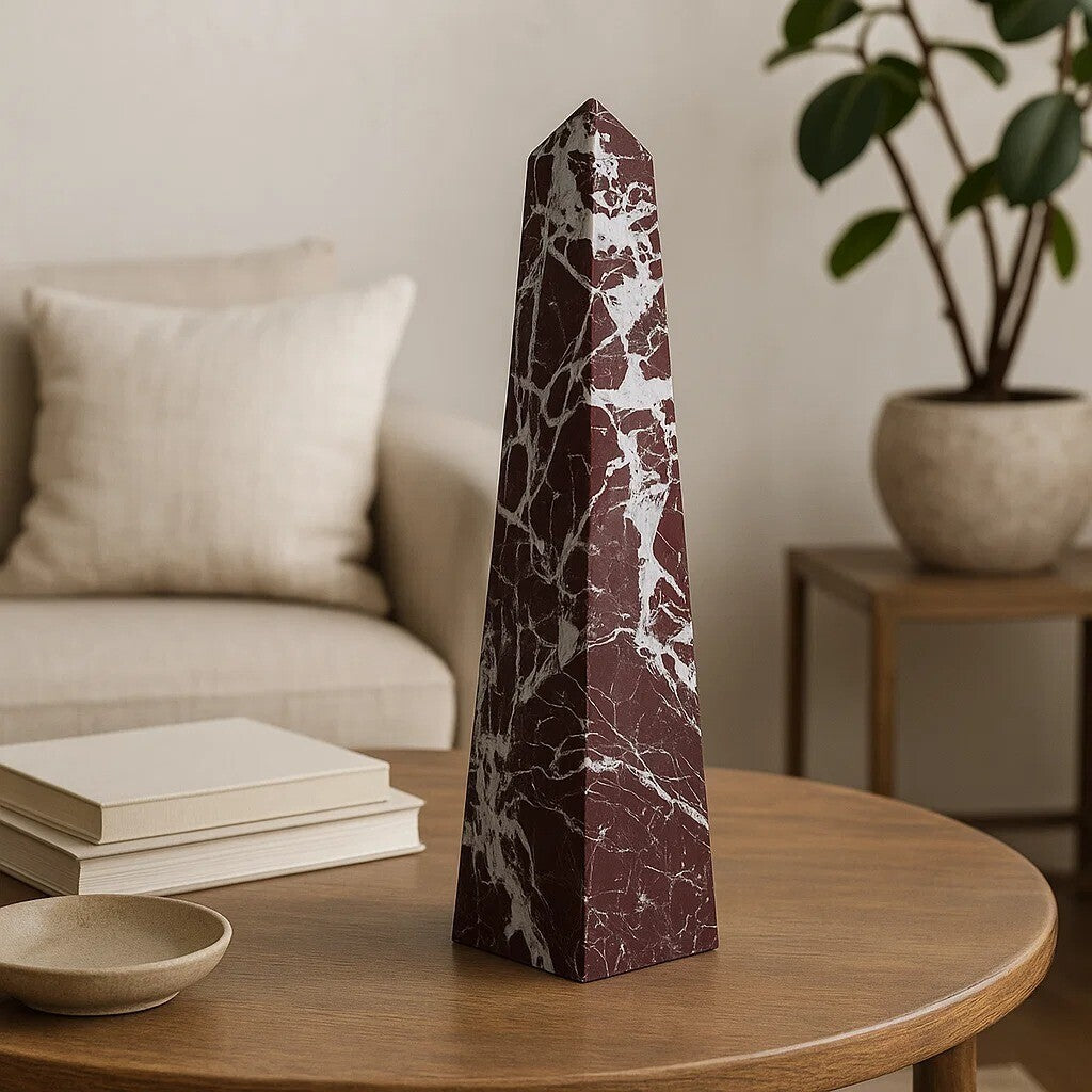 Marble obelisk on a wooden table with a blurred background of a living room.