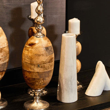 Decorative vases and candles on a dark surface with a dark background