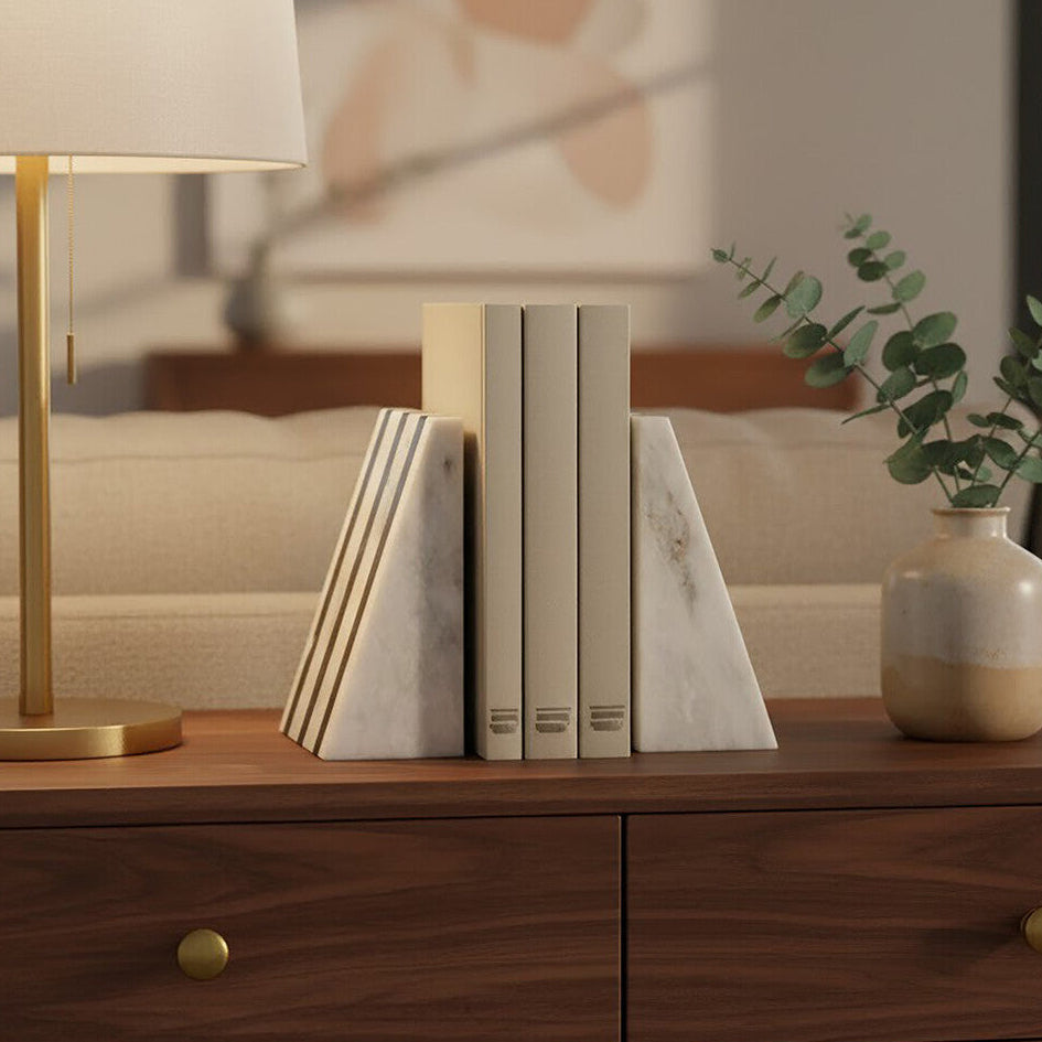 Wooden side table with marble bookends, a lamp, and a vase in a living room setting.