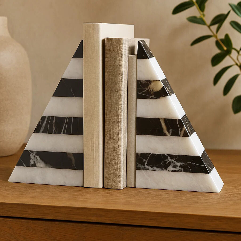 Marble pyramid bookends on a wooden surface with a neutral background