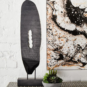 Decorative piece on a table with abstract art in the background