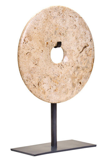 Stone disc on a stand against a white background