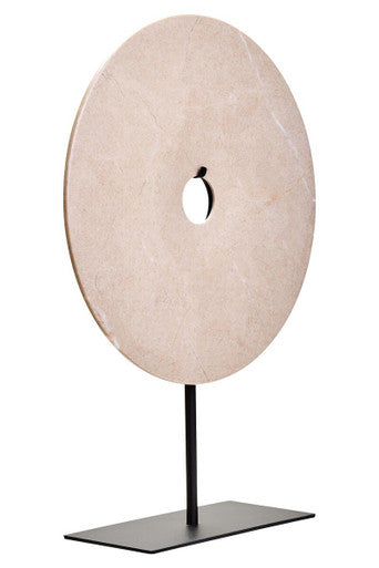 Decorative object with a circular beige disc on a black stand against a white background