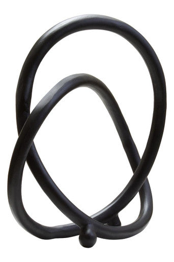 Black metal sculpture with intertwined loops on a white background