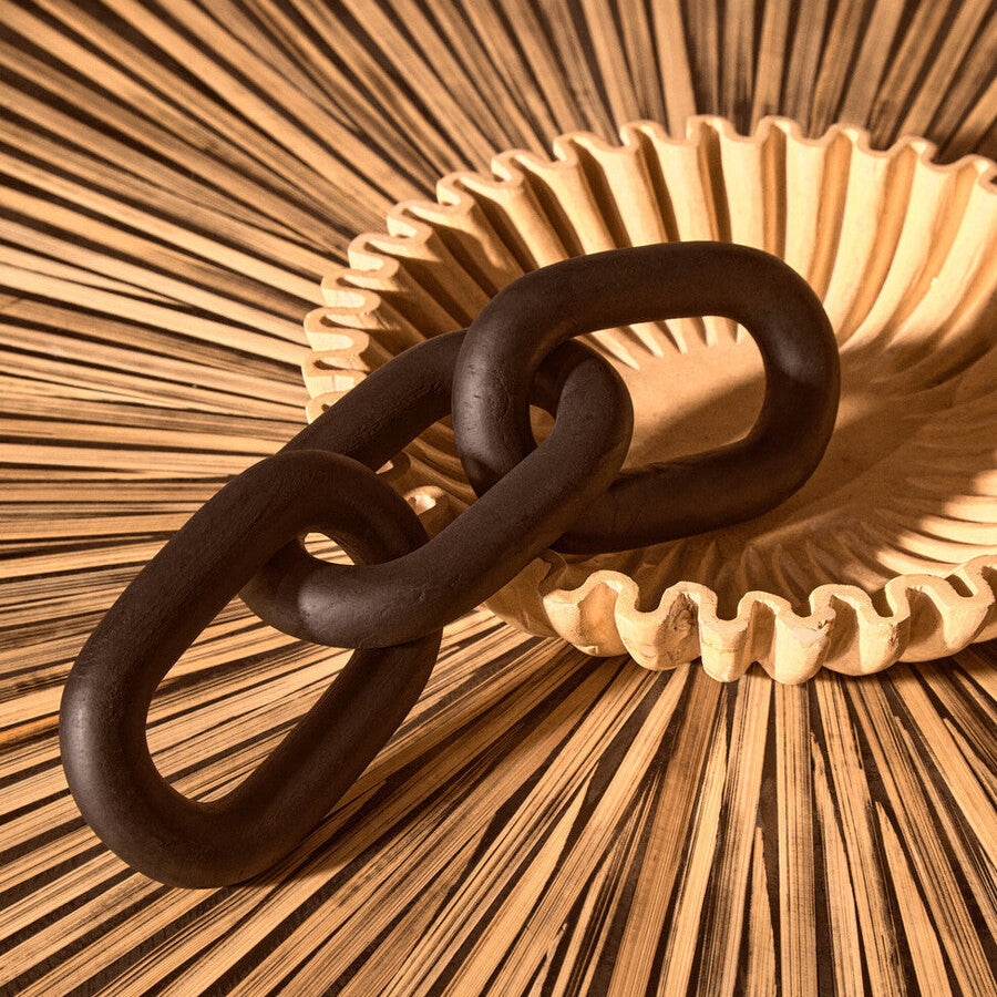 Three interlinked black rings on a textured beige surface