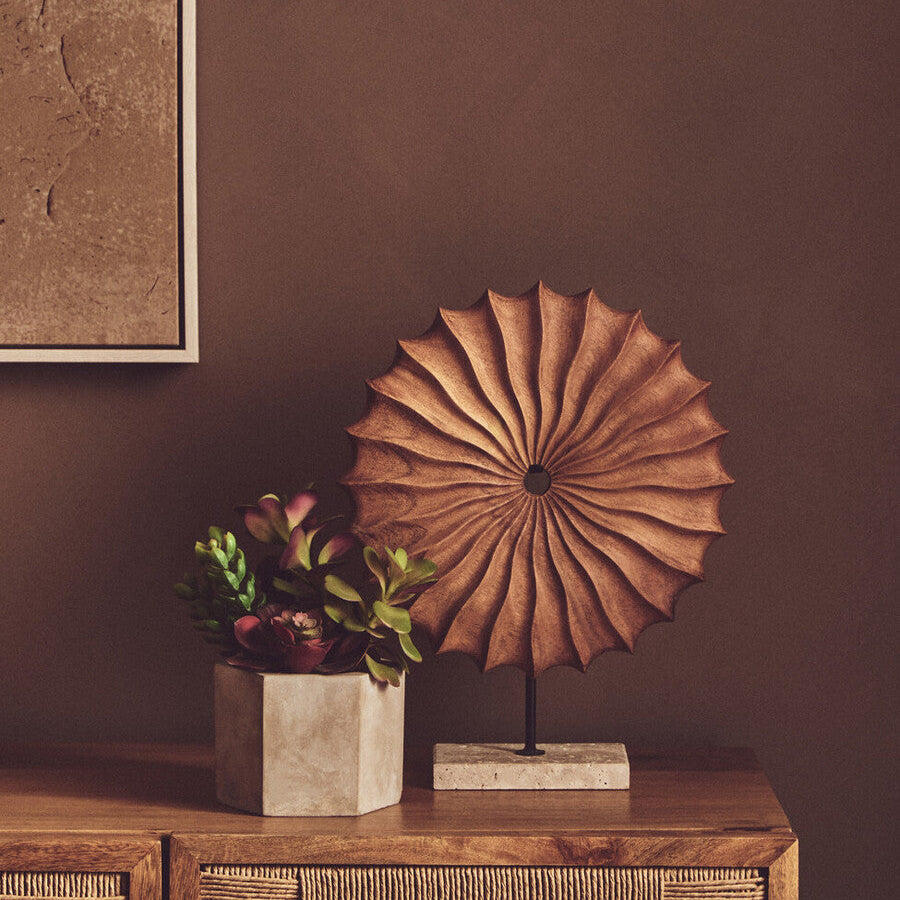 Decorative object on a wooden sideboard against a brown wall