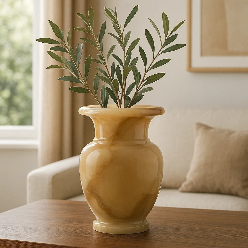 Yellow vase with green leaves on a wooden table in a living room setting