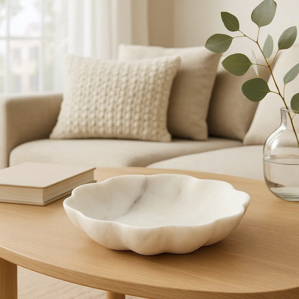 White ceramic bowl on a wooden coffee table with a beige sofa and plant in the background