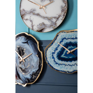 Three decorative wall clocks with agate-like designs on a blue background