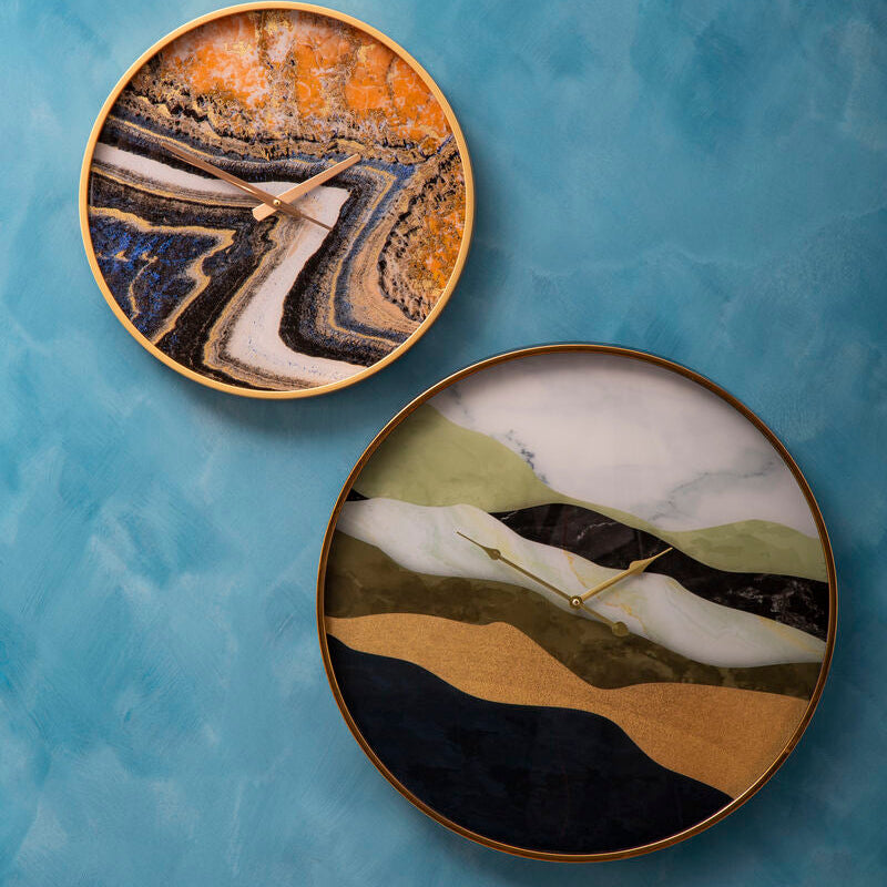 Two decorative plates with abstract landscape designs on a blue textured background