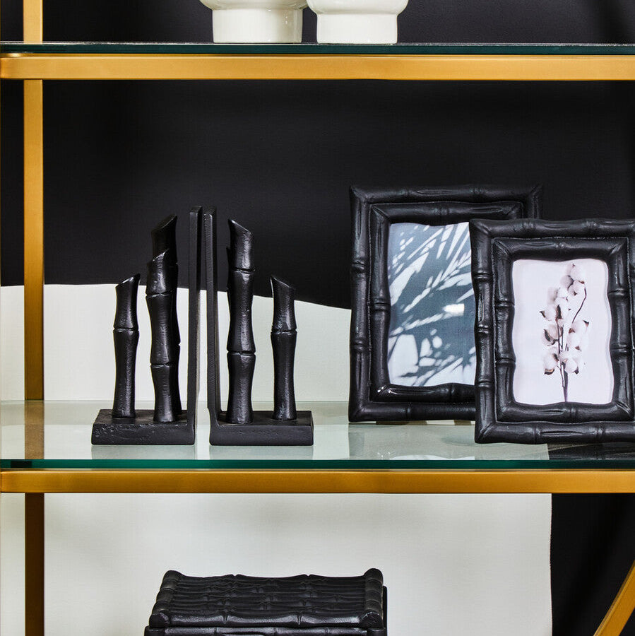 Decorative items including black bamboo sculptures and picture frames on a glass shelf.
